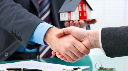 Estate agent shaking hands with customer after contract signature