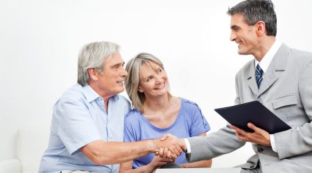 Steuerberater begrüßt zwei Senioren mit einem handschlag